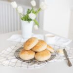 Fraiche living Ciabatta Buns stacked on a rack with fresh tulips