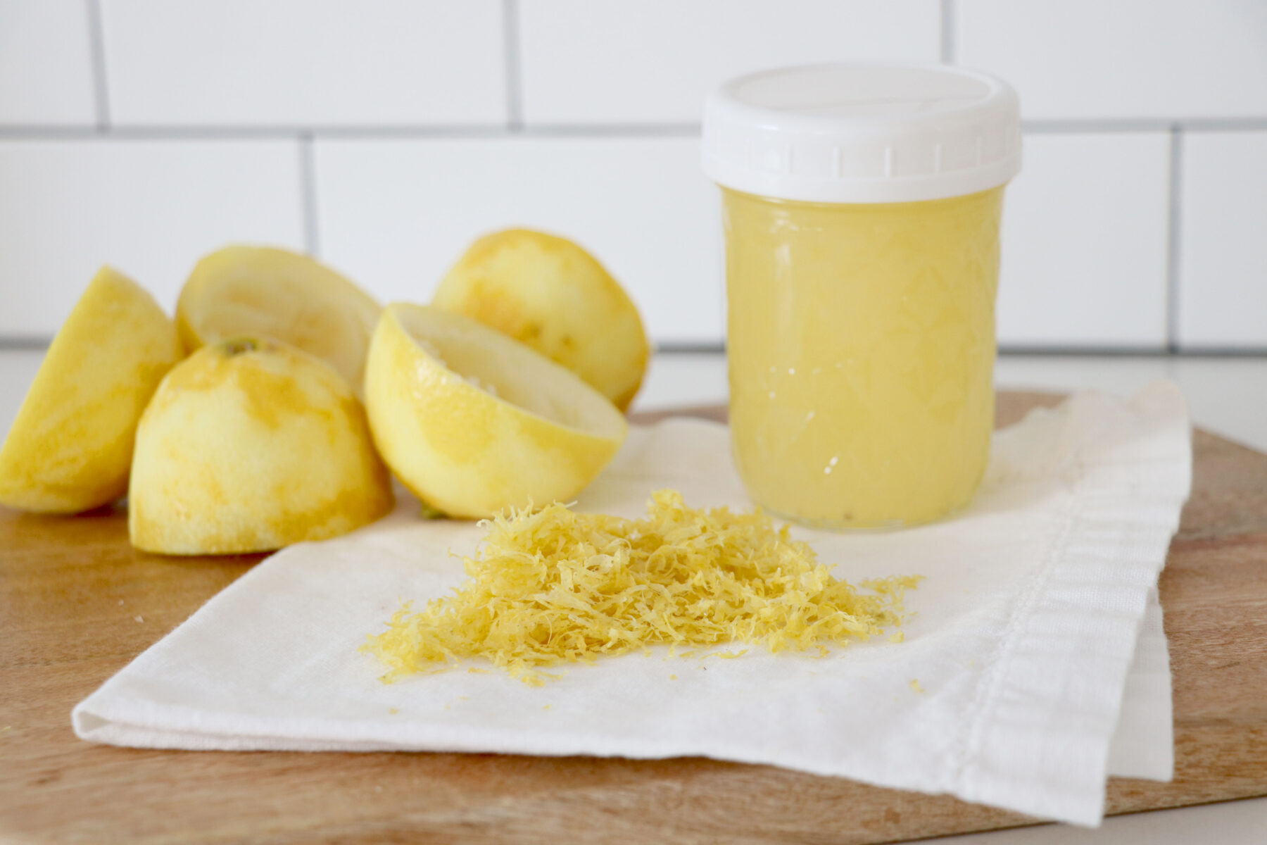Lemon zest on top of paper towel and jar of lemon juice.