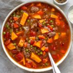 hamburger soup with vegetables in a bowl with a spoon