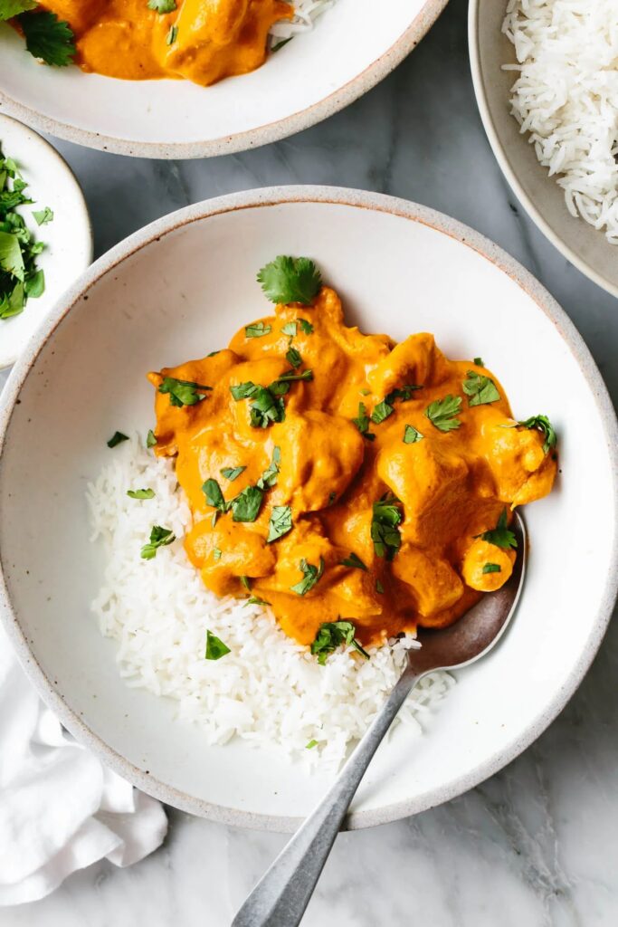 Butter chicken with rice in a bowl.
