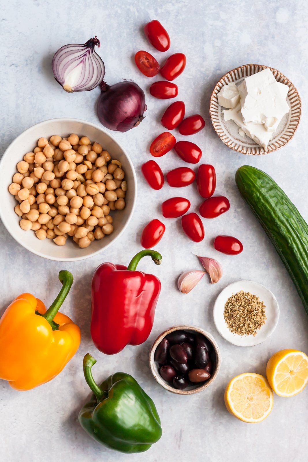 ingredients for a Greek chickpea salad on a grey surface