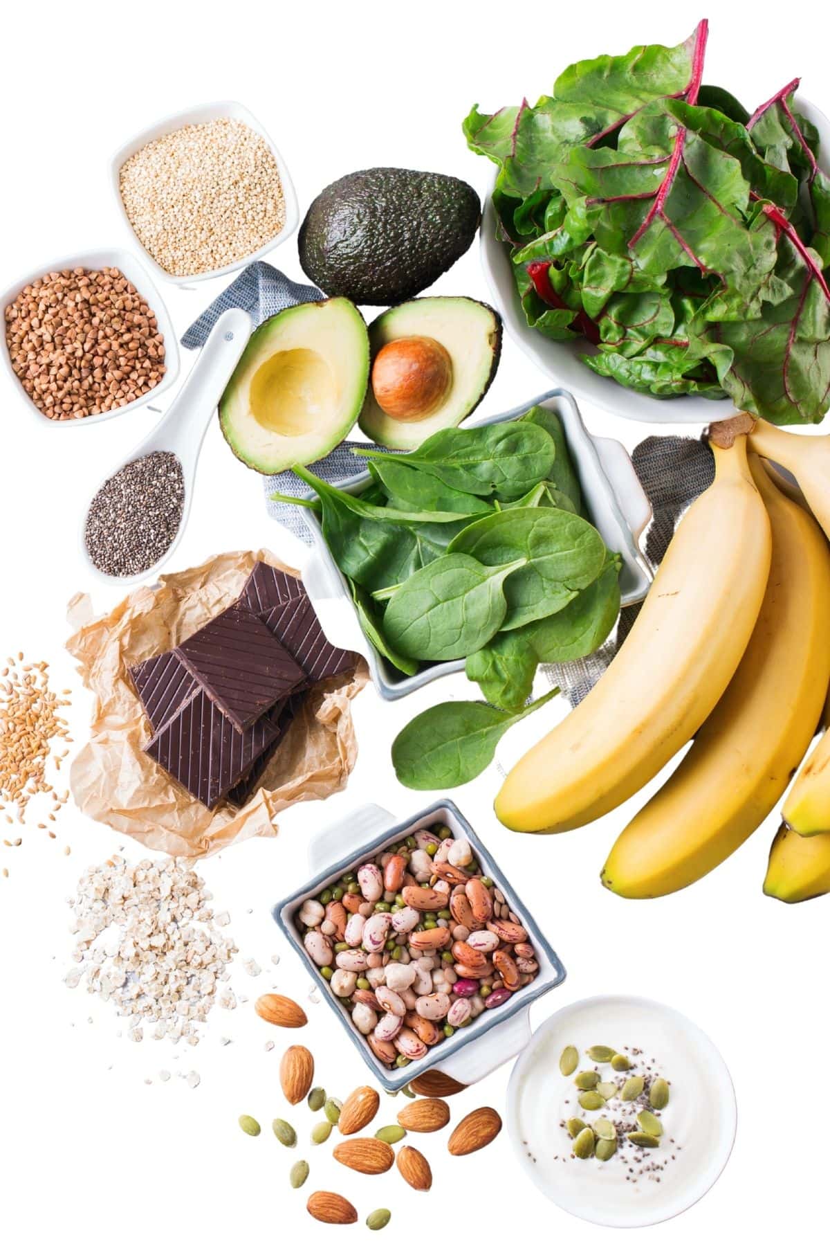 Photo of foods high in magnesium including spinach, Swiss chard, pumpkin seeds, quinoa, chia seeds, avocado, almonds, dark chocolate, bananas, and beans.