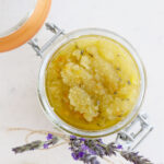 Glass container with body scrub and lavender.