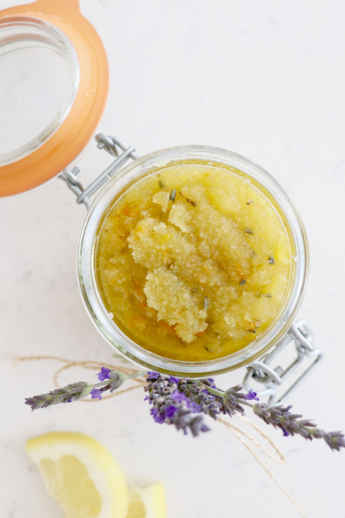 Glass container with body scrub and lavender.
