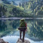 Backpacker looks over a mountain lake