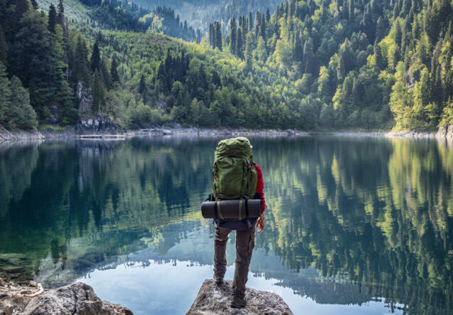 Backpacker looks over a mountain lake