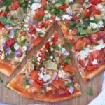 Greek Pizza is loaded with feta cheese, artichokes, tomatoes, red peppers, parsley, red onion and more for a flavor packed pizza ready in no time!