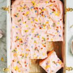 photo of pink sheet cake on marble backdrop with slices