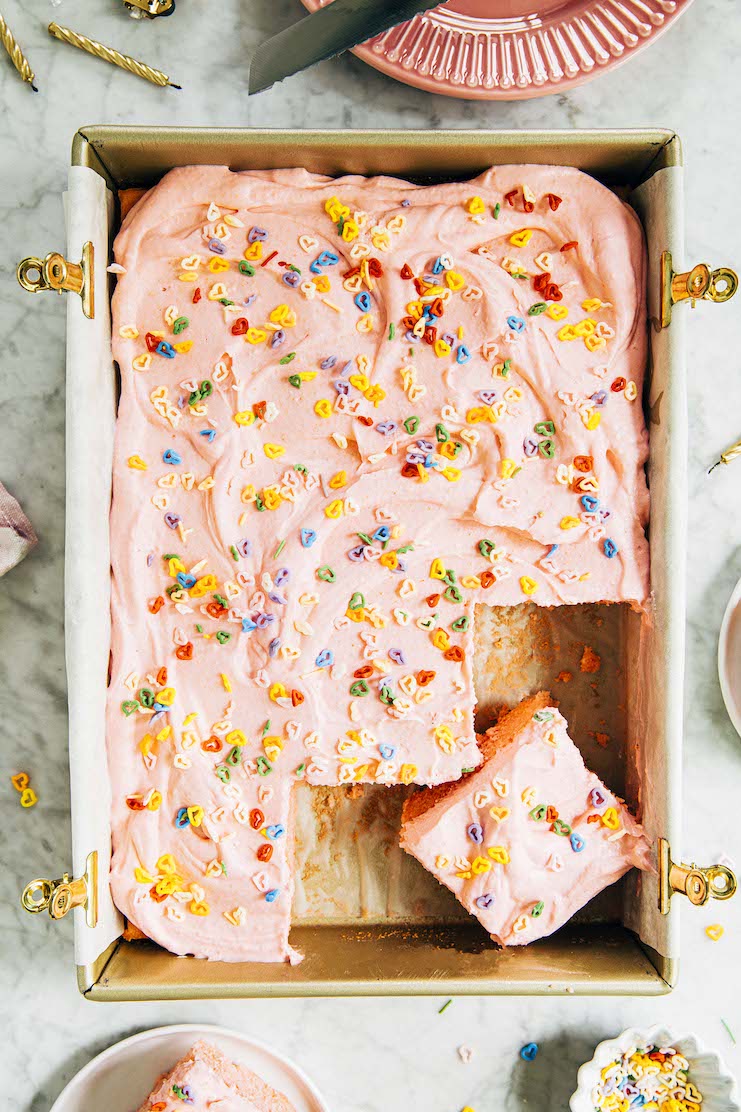 photo of pink sheet cake on marble backdrop with slices