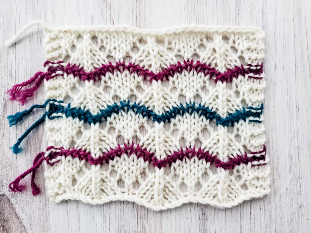 hand knit rectangle with lace pattern in three colors