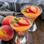2 peach bellinis topped with strawberry slices