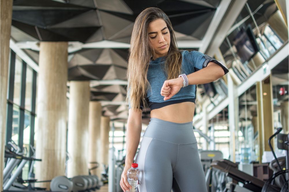 sportswoman checking her exercise activity and burned calories on smartwatch