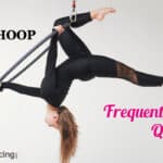 a hoop dancer doing an aerial hoop pose on aerial lyra hoop