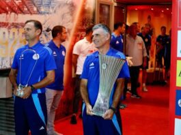 Olympiacos manager Jose Luis Mendilibar holds the Conference League trophy before his side's pre-season game against Nottingham Forest on August 8, 2024