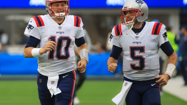 New England Patriots quarterbacks Mac Jones and Brian Hoyer running on to the field before they play the Los Angeles Chargers during NFL action at SoFi Stadium. (Matthew J Lee/Globe staff)